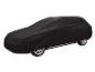 Car covered with a black protective cover on a black background