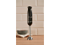 Black hand blender with '1973' inscription on a wooden counter with a bowl.