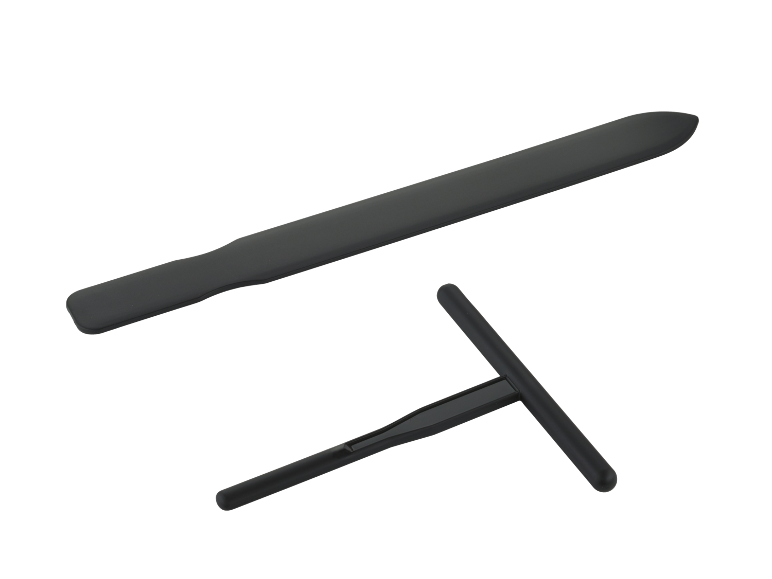 Black silicone spatula and T-shaped dough scraper on a black background.