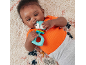 Baby lying on a rug, playing with a squirrel-shaped teether.