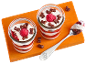 Yogurt dessert with raspberries and chocolate cereal in glasses, with a spoon.