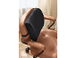 Black lumbar cushion on a brown leather office chair