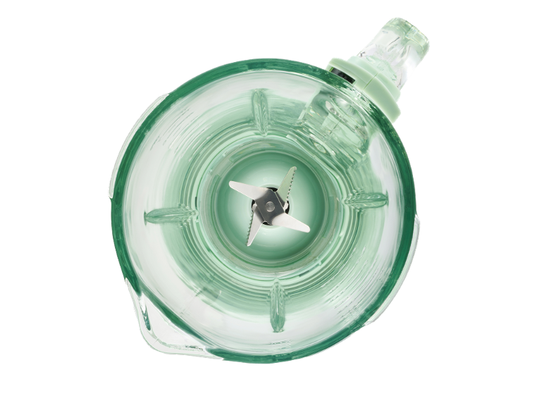 Top view of a glass blender jug with metal blades on a black background.