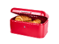 Red bread bin with an open lid and fresh croissants inside.