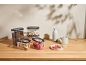 Clear food containers with coffee, legumes, nuts, and dried fruit on a wooden table.