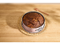 Chocolate cake in a pink springform pan on a woven placemat and wooden table.