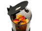 Blender with fruit pieces, including orange, apple, and mango, ready for juicing.