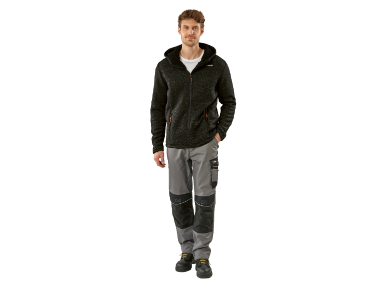 Man in a hooded knit jacket and grey work trousers with black details.