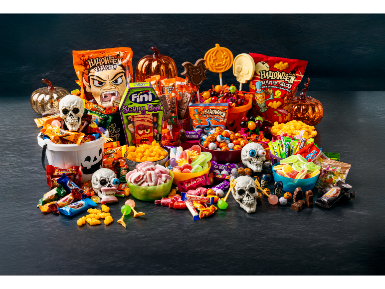 A spooky Halloween candy assortment featuring Sweet Corner Party Mix Minis and themed treats.