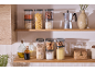Kitchen shelves with transparent storage jars filled with pasta, cereals, and legumes.