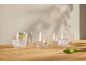 Glasses with sparkling water, lime, and mint on a wooden table.