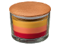 Layered candle in a glass jar with a wooden lid, featuring red, orange, and yellow wax.