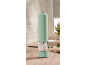 Light green electric salt and pepper grinder on a wooden kitchen countertop.