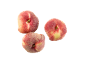 Three flat peaches with red and yellow skin on a black background.