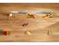 Two kitchen knives with fresh, chopped vegetables on a wooden table.
