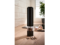 Black electric pepper grinder on a wooden kitchen counter with scattered peppercorns.