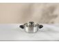 Silver pot with a glass lid on a white marble surface.