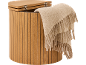 Wooden storage stool with a light beige blanket draped over the side.