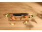 Kitchen knife on a wooden board with salmon pieces, lemon, and peas.