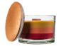 Multicolor scented candle in a glass jar with a wooden lid.