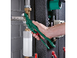 Hand holding green pipe wrench, working on plumbing.