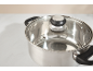 Stainless steel pot with a glass lid and black handles