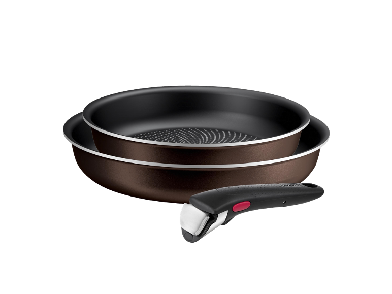 Stackable brown frying pans with detachable handles on a black background.