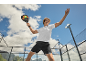 Man in sportswear playing padel on an outdoor court.