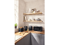 Kitchen with black toaster, kettle, air fryer, and microwave on a wooden countertop.
