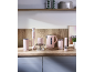 Pink kitchen appliance set on a wooden counter: kettle, hand blender, chopper, milk frother, and salt/pepper grinder.