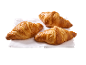 Three golden croissants on a white napkin.