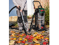 Person using a wet/dry vacuum cleaner to clear fallen leaves from a patio.