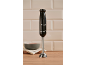 Black immersion blender with the numbers '1973' on a wooden surface with a bowl.