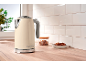 Cream retro kettle on a wooden countertop with cookies and sugar.