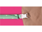 Green polka dot strap with a white buckle on brown fabric.