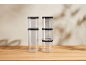 Clear plastic containers with black lids, stacked on a wooden table.