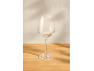 Empty wine glass on a wooden table with shadows on the wall