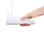 Hand holding a white portable oral irrigator being filled with water.