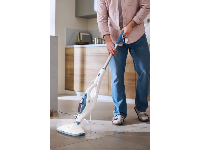 Man cleaning kitchen floor with a steam mop.