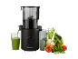 Black juicer with a glass of green juice and fresh vegetables.