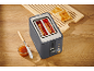 Toaster with bread inside, two slices of toast on a wooden board, and jam with a knife.