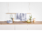 Kitchen counter with checkered tea towels, cooking utensils, cauliflower, and herbs.