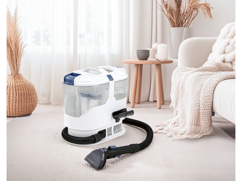 Carpet cleaner in a bright living room with a beige rug and sofa.