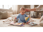 Baby playing with fabric books and a fabric ball on a rug.