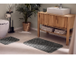 Grey bath mats in a modern bathroom with a wooden vanity unit and plants.