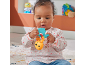 Baby sitting on a rug, playing with a yellow and blue rattle.