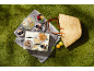 Ice cream, waffles, and fruit on a picnic blanket on the grass, on a sunny day.