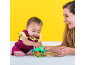 Mother and baby playing with a green frog toy against a yellow background.