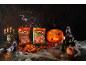 Halloween fruit candies in bags, pumpkins, candles, and spiderwebs on a dark background.