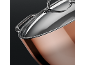 Close-up of a shiny copper pot with a stainless steel lid and handle.